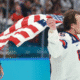 Charlie McAvoy (Bruins) skates with a USA flag after beating Canada 2-1 in the gold medal game
